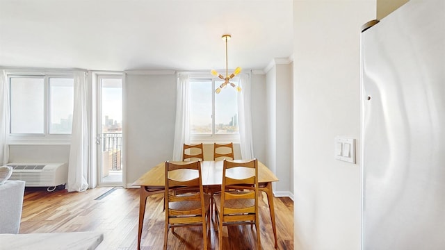 dining area featuring ornamental molding and light wood finished floors