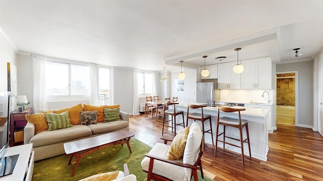 living room with baseboards, ornamental molding, and wood finished floors