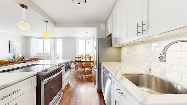kitchen featuring decorative backsplash, appliances with stainless steel finishes, a sink, white cabinetry, and dark wood-type flooring