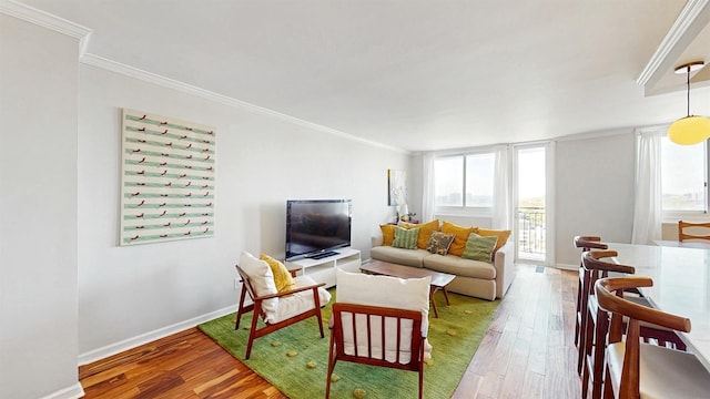 living room featuring baseboards, ornamental molding, and hardwood / wood-style floors