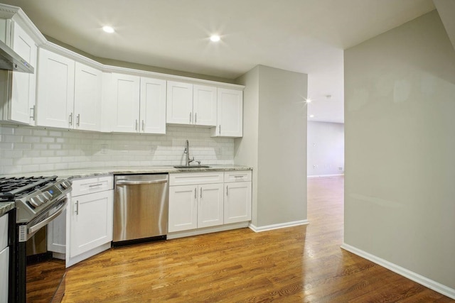 kitchen featuring white cabinets, light stone countertops, light wood-type flooring, and appliances with stainless steel finishes