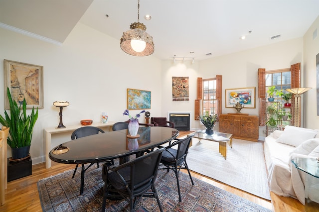 101 Park Ave Unit 3A, Hoboken, NJ 07030 - dining space featuring a glass covered fireplace, wood finished floors, plenty of natural light, baseboards, and ornamental molding