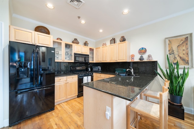 101 Park Ave Unit 3A, Hoboken, NJ 07030 - kitchen featuring black appliances, a sink, light brown cabinetry, a breakfast bar area, and ornamental molding