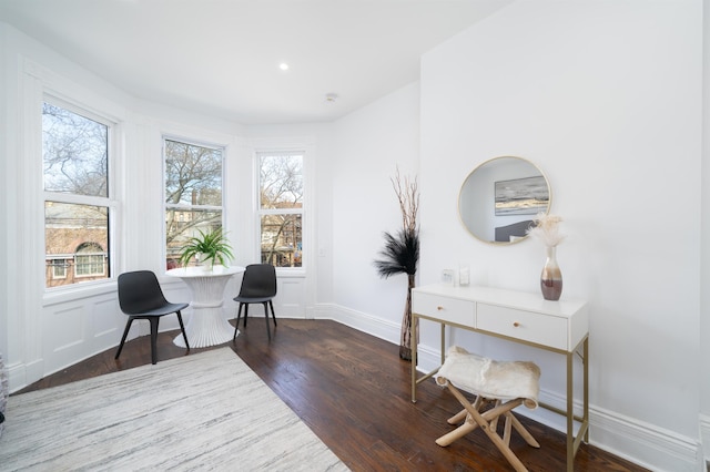 sitting room featuring baseboards, wood finished floors, and a healthy amount of sunlight