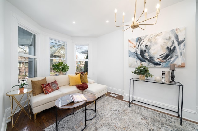 living area with baseboards, recessed lighting, wood finished floors, and a chandelier