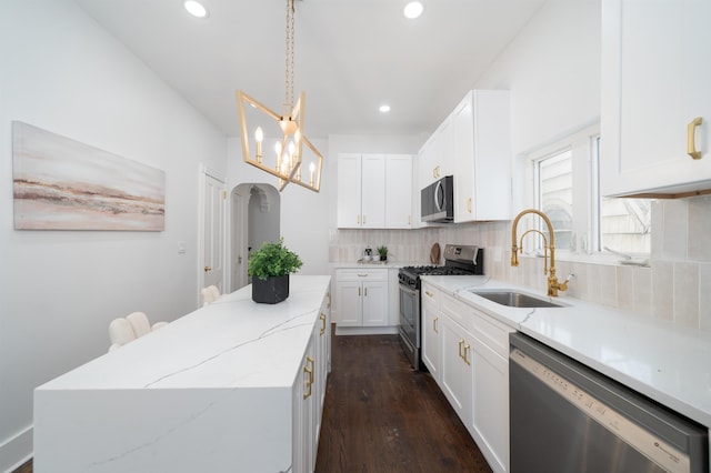 kitchen featuring a kitchen island, tasteful backsplash, a sink, dark wood-style floors, and stainless steel appliances