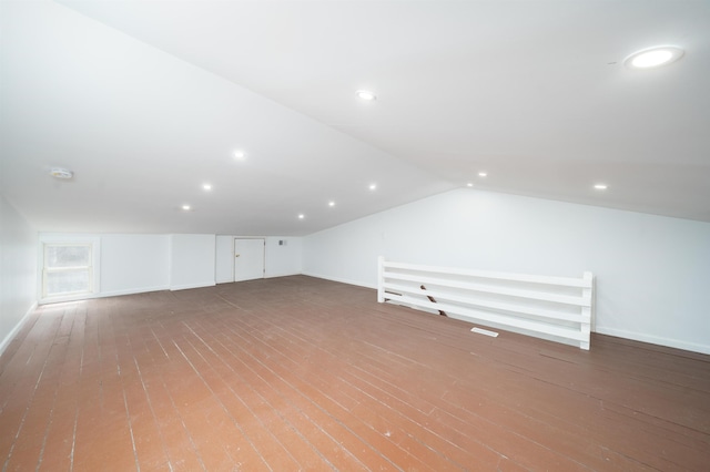 additional living space with baseboards, recessed lighting, lofted ceiling, and hardwood / wood-style flooring