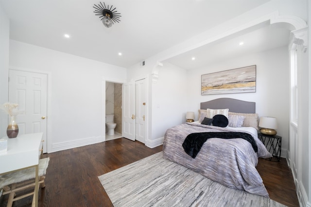 bedroom with recessed lighting, baseboards, wood finished floors, ensuite bathroom, and visible vents