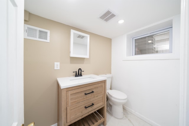 bathroom featuring vanity, baseboards, toilet, and visible vents