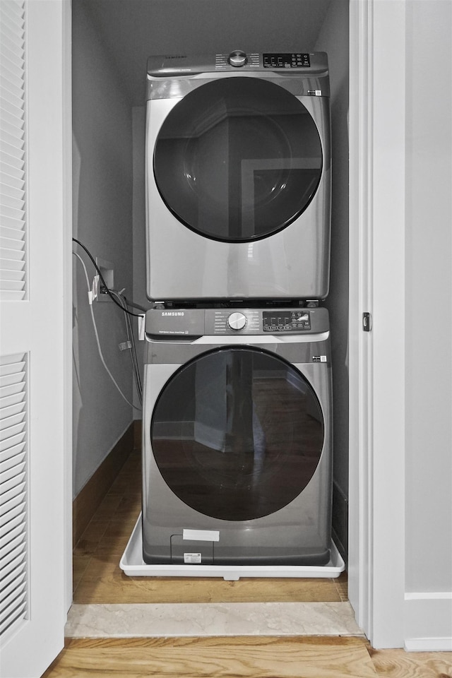 clothes washing area featuring stacked washing maching and dryer