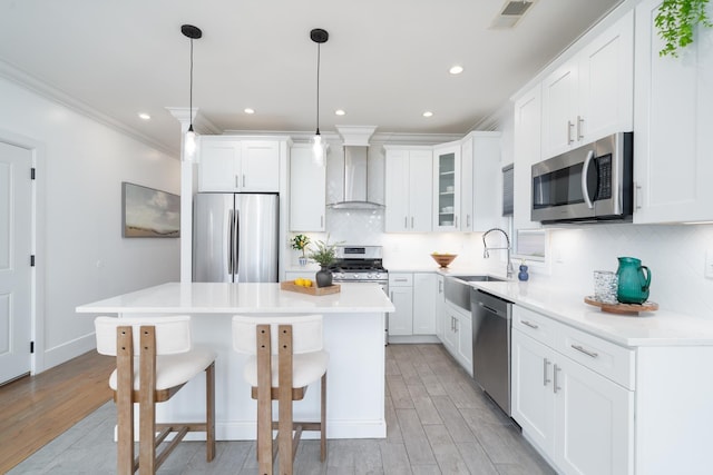 104 Poplar St Unit 1, Jersey City, NJ 07307 - kitchen featuring stainless steel appliances, wall chimney range hood, a kitchen bar, light wood-style flooring, and a center island