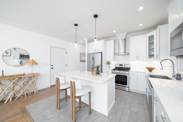 104 Poplar St Unit 1, Jersey City, NJ 07307 - kitchen featuring wall chimney exhaust hood, appliances with stainless steel finishes, a kitchen island, light wood-style flooring, and recessed lighting