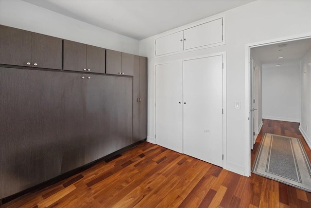 unfurnished bedroom featuring dark wood-type flooring and a closet