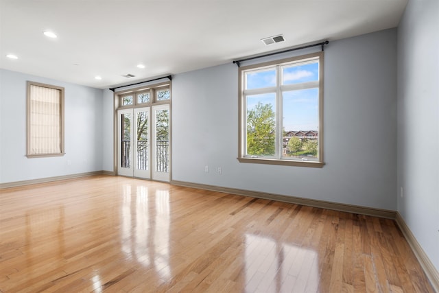 unfurnished room featuring light wood-style floors, visible vents, baseboards, and recessed lighting