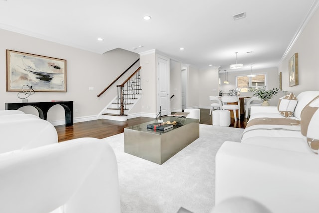 living room with crown molding and dark wood-type flooring