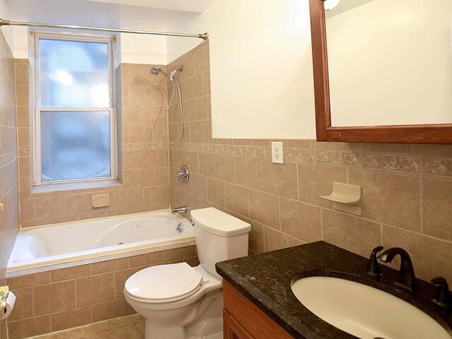 133 Lafayette St Unit 3R, Jersey City, NJ 07304 - bathroom featuring tiled shower / bath, tile walls, vanity, and tile patterned floors