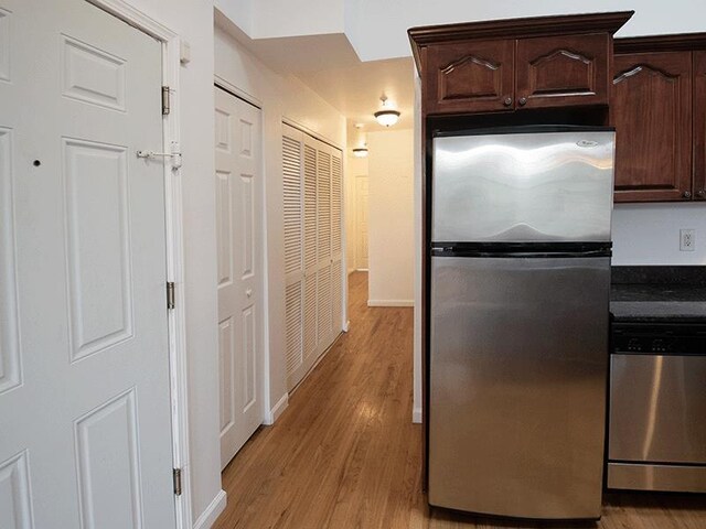 133 Lafayette St Unit 3R, Jersey City, NJ 07304 - kitchen with appliances with stainless steel finishes, light wood-style floors, dark brown cabinets, and dark countertops