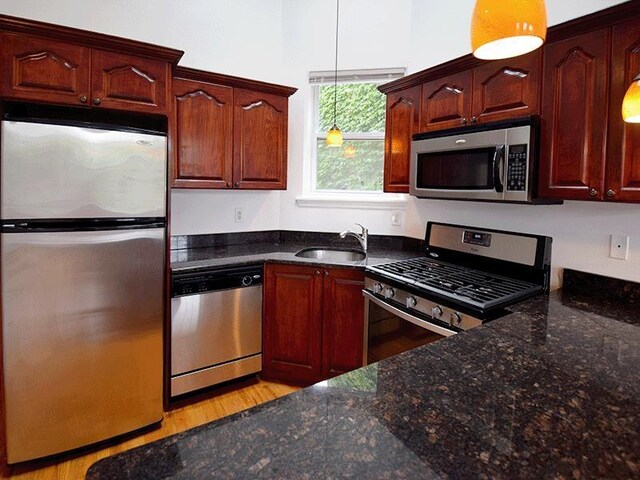 133 Lafayette St Unit 3R, Jersey City, NJ 07304 - kitchen featuring appliances with stainless steel finishes, pendant lighting, light wood-style flooring, and dark stone counters