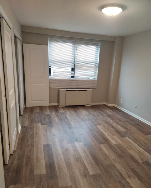 spare room featuring hardwood / wood-style floors and radiator heating unit