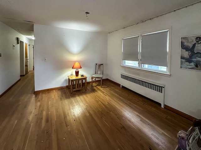 empty room featuring radiator heating unit and wood-type flooring