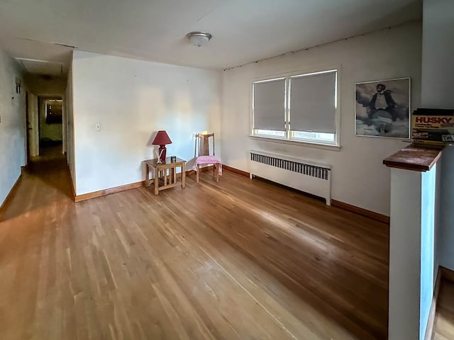 sitting room with radiator and hardwood / wood-style flooring