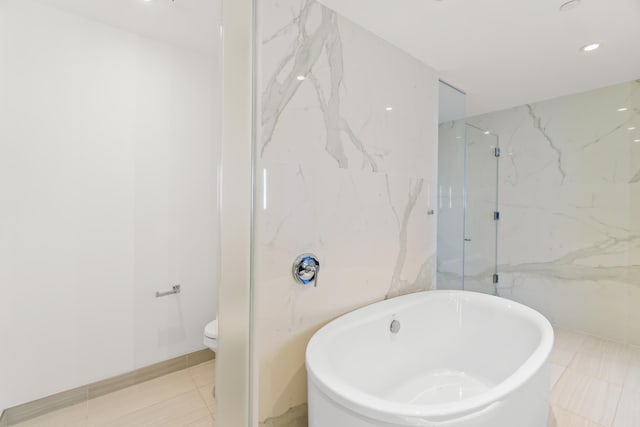 full bath with tile walls, a marble finish shower, recessed lighting, toilet, and a freestanding tub