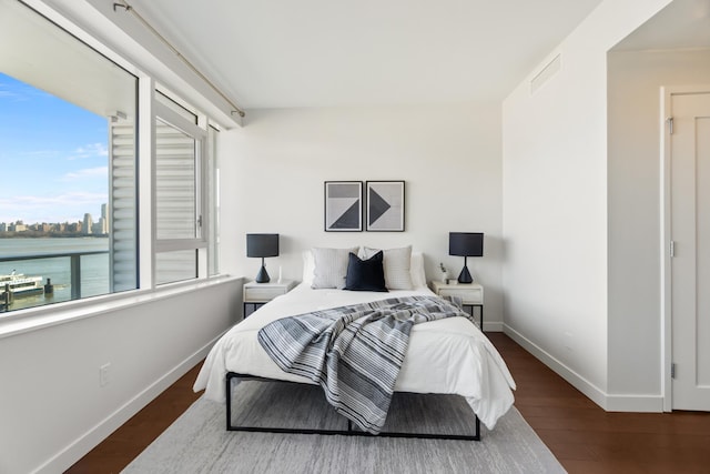 bedroom featuring wood finished floors, visible vents, and baseboards