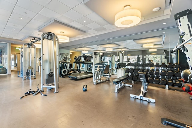 exercise room featuring a raised ceiling and a drop ceiling