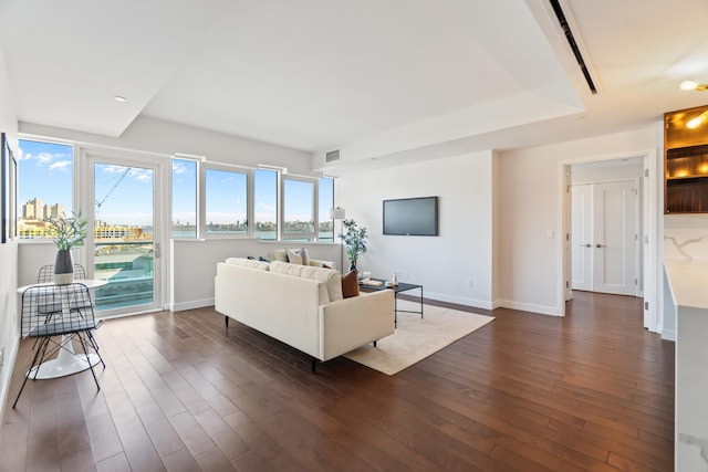 living room featuring dark wood-type flooring, visible vents, and baseboards