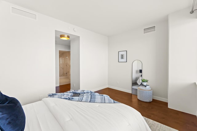 bedroom featuring baseboards, visible vents, and wood finished floors