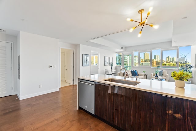 kitchen featuring dark wood-style floors, light countertops, stainless steel dishwasher, open floor plan, and a sink