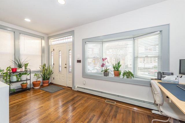 foyer entrance with a baseboard heating unit, recessed lighting, wood finished floors, and visible vents