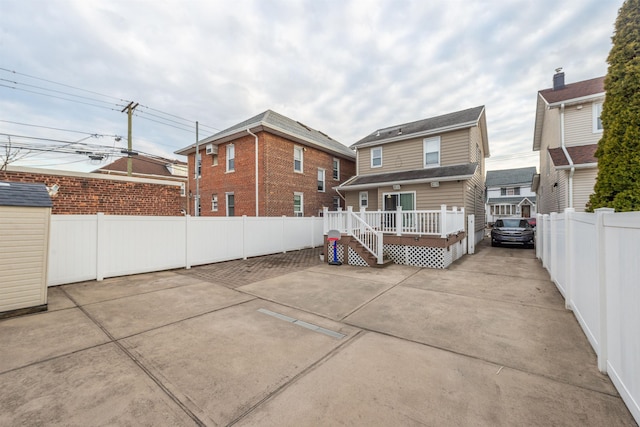 rear view of property with a deck, a fenced backyard, and a patio area