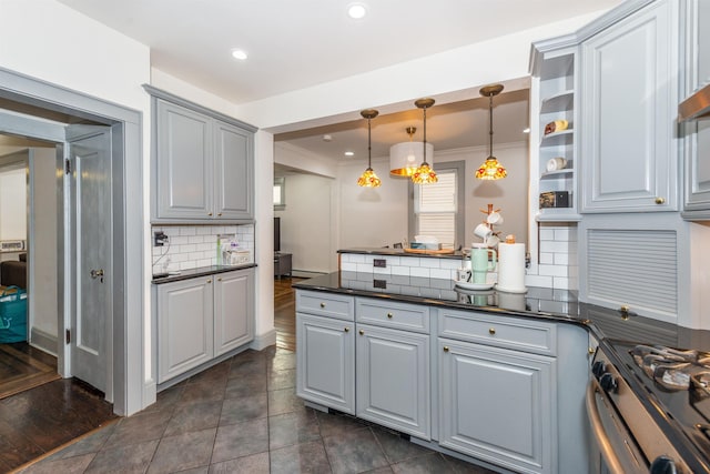 kitchen with dark countertops, a peninsula, gray cabinets, decorative backsplash, and gas range