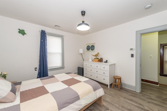 bedroom with visible vents, baseboards, and light wood-style flooring