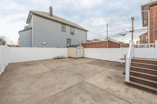 back of property with a fenced backyard, a shed, an outbuilding, and a patio