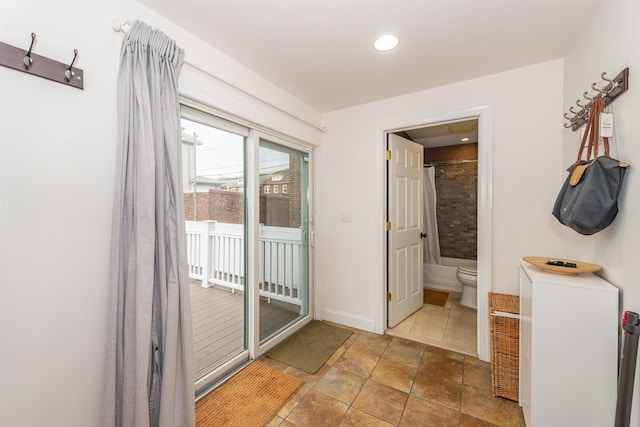 interior space featuring tile patterned flooring, toilet, baseboards, and shower / bathtub combination with curtain