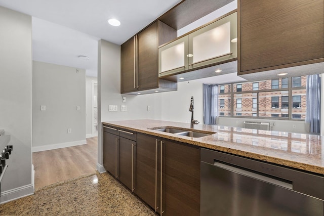 kitchen with sink, dark brown cabinets, dishwasher, and light stone counters