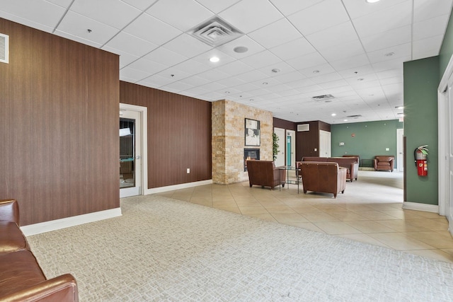 unfurnished living room with a stone fireplace and light tile patterned flooring