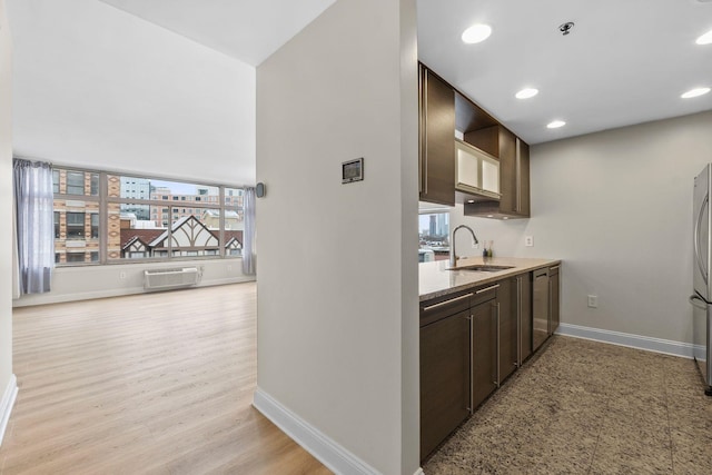 kitchen featuring light hardwood / wood-style flooring, stainless steel appliances, a wall mounted air conditioner, dark brown cabinets, and sink