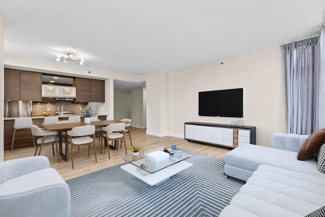 living room featuring light wood-type flooring and sink