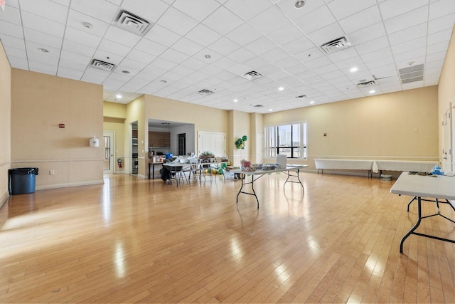 exercise area featuring light hardwood / wood-style floors and a paneled ceiling