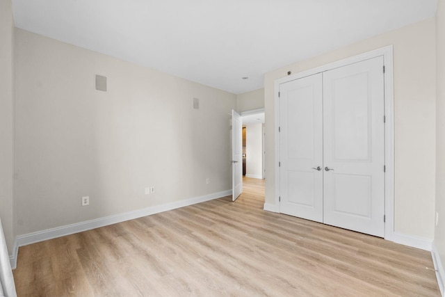 unfurnished bedroom featuring a closet and light hardwood / wood-style floors