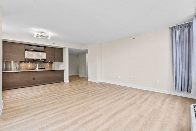 unfurnished living room with sink and light wood-type flooring