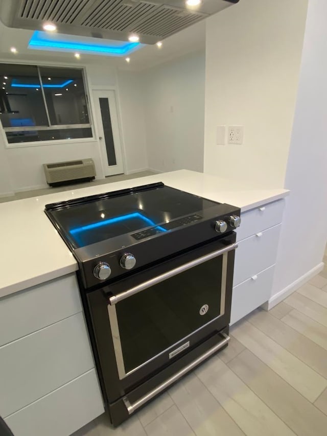 100 Manhattan Ave Unit 1301, Union City, NJ 07087 - kitchen with black range with electric cooktop, light countertops, white cabinets, extractor fan, and light wood-type flooring