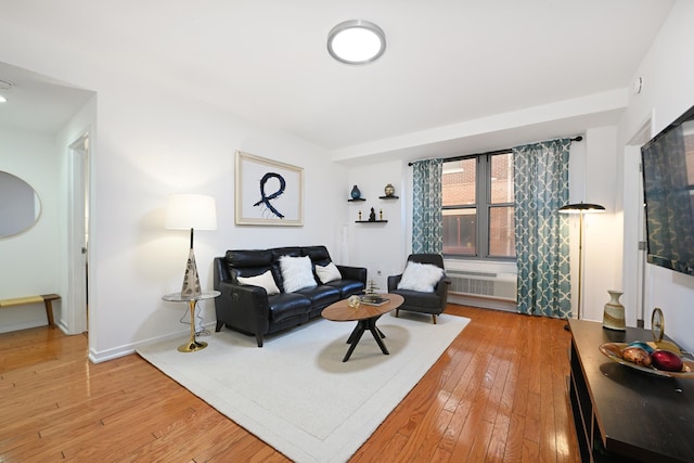 living room with an AC wall unit and hardwood / wood-style floors