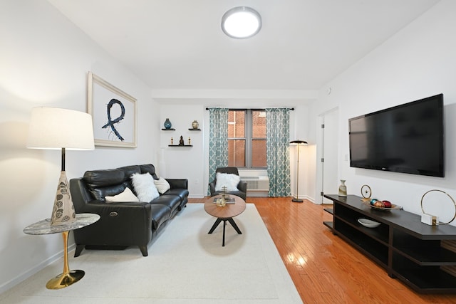 living room with a wall mounted AC and hardwood / wood-style flooring