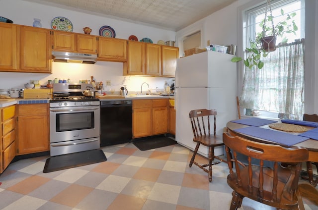 329 Adams St Unit 4, Hoboken, NJ 07030 - kitchen with stainless steel gas range oven, freestanding refrigerator, black dishwasher, under cabinet range hood, and healthy amount of natural light