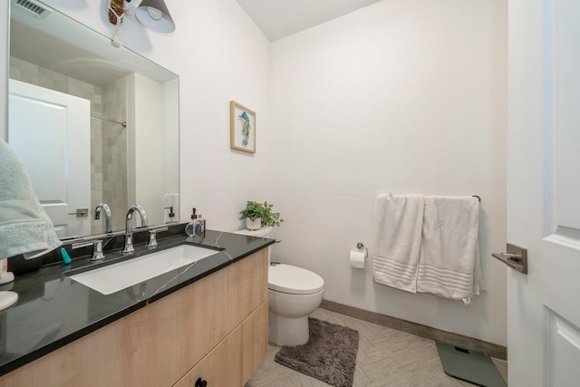 bathroom featuring vanity, baseboards, visible vents, walk in shower, and toilet