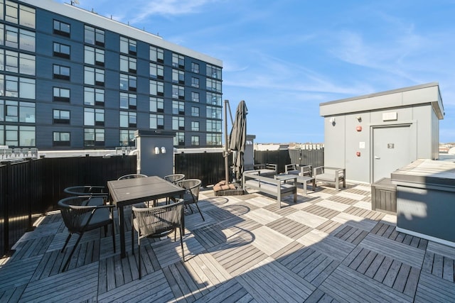 deck with outdoor dining area and fence